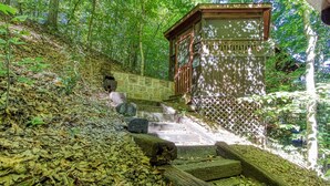 A staircase leading to a wooden structure in a forested area. - Er96 - Squirrel's Leap - Great Location! Close To Town! 2 Bedroom Cabin by RedAwning (Pigeon Forge)