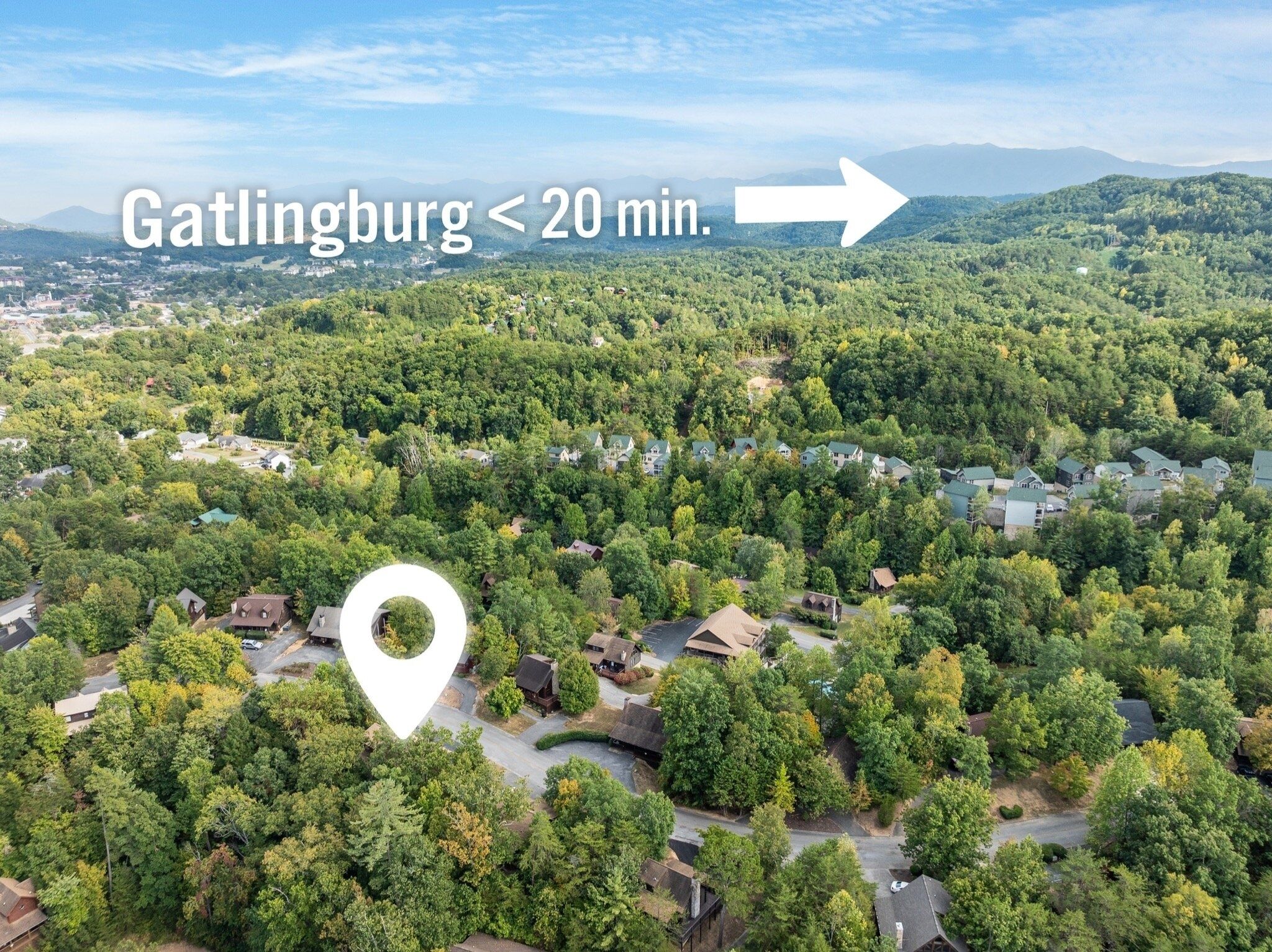 An aerial view of a residential area with a prominent white location marker indicating a specific point.