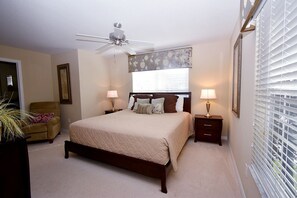A bedroom with a bed, two bedside tables, a ceiling fan, a window with blinds, and a chair. - Paradise Palms -5 Bed Townhome W-splashpool-3046pp 5 Bedroom Townhouse by RedAwning (Kissimmee)