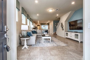A spacious living room with a sectional sofa, a coffee table, and a television.