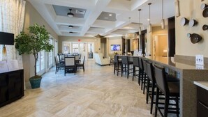 A hotel lobby with a reception desk, bar area, and seating.
