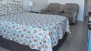 Une chambre à coucher avec un lit, un canapé et un ventilateur de plafond.