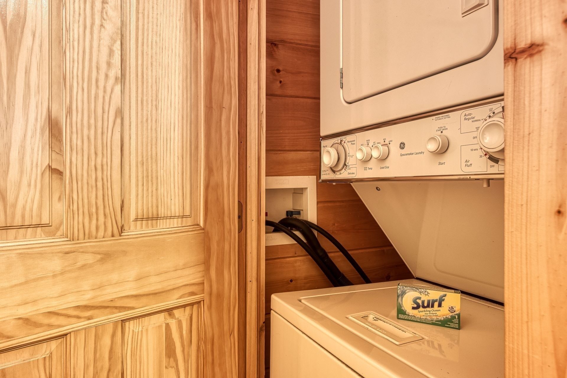 A laundry room with wooden cabinets and a washing machine.