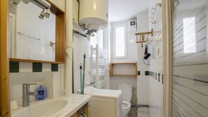 Kylpyhuone, jossa on pesuallas, peili, wc ja suihku.