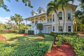 A large, two-story house with a covered porch and multiple windows. - Florida Estate Home w/ Bay View (Marco Island)