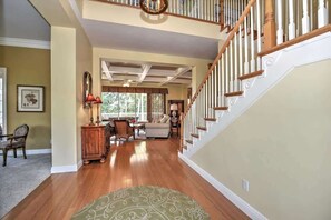 A spacious living area with a wooden staircase, a dining area, and a view to the outside. - Florida Estate Home w/ Bay View (Marco Island)