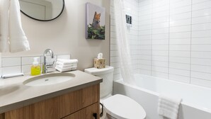 Une salle de bain moderne avec un lavabo, des toilettes et une baignoire.