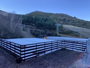 A rooftop terrace with a metal roof, a brick floor, and a metal railing. - Hostal La Pinilla (Cerezo de Arriba)