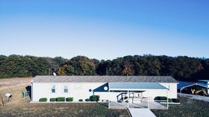 A single-story building with a flat roof, a covered porch, and a satellite dish.