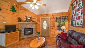 A cozy cabin interior with a fireplace, wooden walls, a leather sofa, and a television. - Er307- Eagle's View- Great Location- Close To Town 2 Bedroom Cabin by RedAwning (Pigeon Forge)