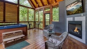 A wooden deck with a hot tub, wicker chairs, and a fireplace. - Ern824 - Best Days - Great Location! Close To Town! 2 Bedroom Cabin by RedAwning (Pigeon Forge)