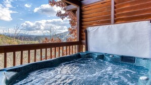 A hot tub with a view of mountains and autumn trees.