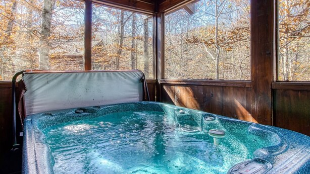 A hot tub in a wooden cabin with large windows overlooking a forest. - Er84 - Serenity Summit - Great Location. Close To All The Action! 1 Bedroom Cabin by RedAwning (Pigeon Forge)