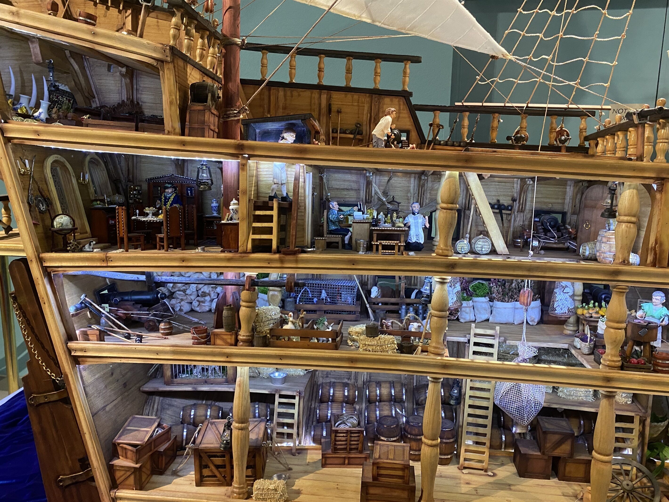 Une structure en bois à plusieurs niveaux, comprenant divers objets et figurines.