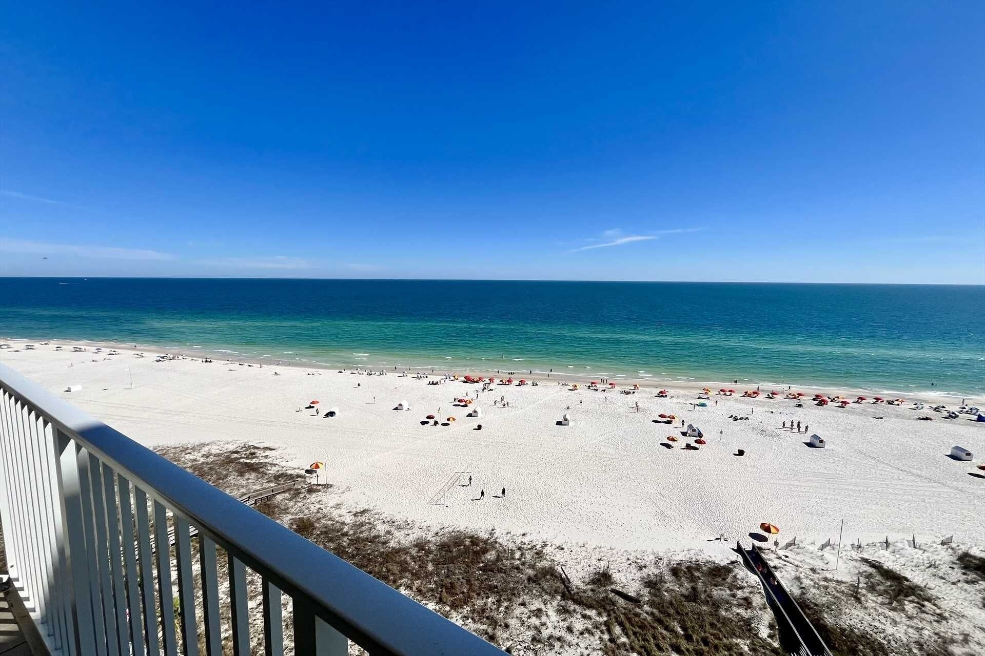 A beach with white sand and a clear blue sky.