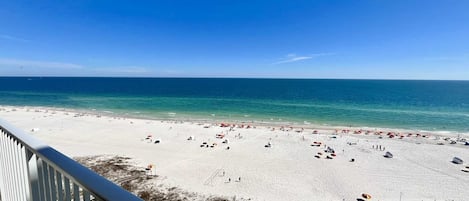 Una playa de arena blanca y cielo azul despejado.