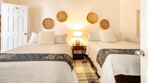 A double room with two beds, a nightstand with a lamp, and a woven wall hanging. - Blue Horizon one bedroom apartment B Quepos Complimentary access to Beach Club (Quepos)