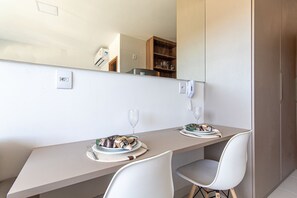A modern dining area with a long table, two chairs, and a large mirror above. - Mana Beach Experience B16 - Carpediem (Ipojuca)
