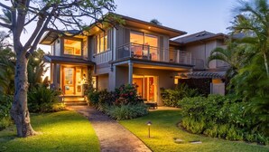 Une maison à deux étages dotée d’un balcon, d’une pelouse bien entretenue et d’un chemin menant à l ’entrée.