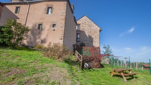 Ein historisches Gebäude mit einer Stein-Fassade, einem Glockenturm und einem Picknicktisch im Vordergrund.