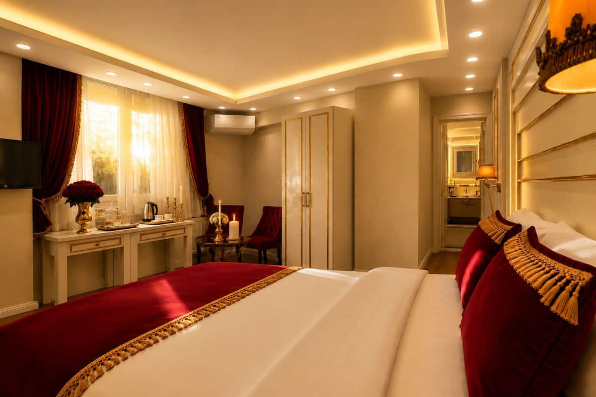 A hotel room with a large bed, a desk, a chair, and a mirror.