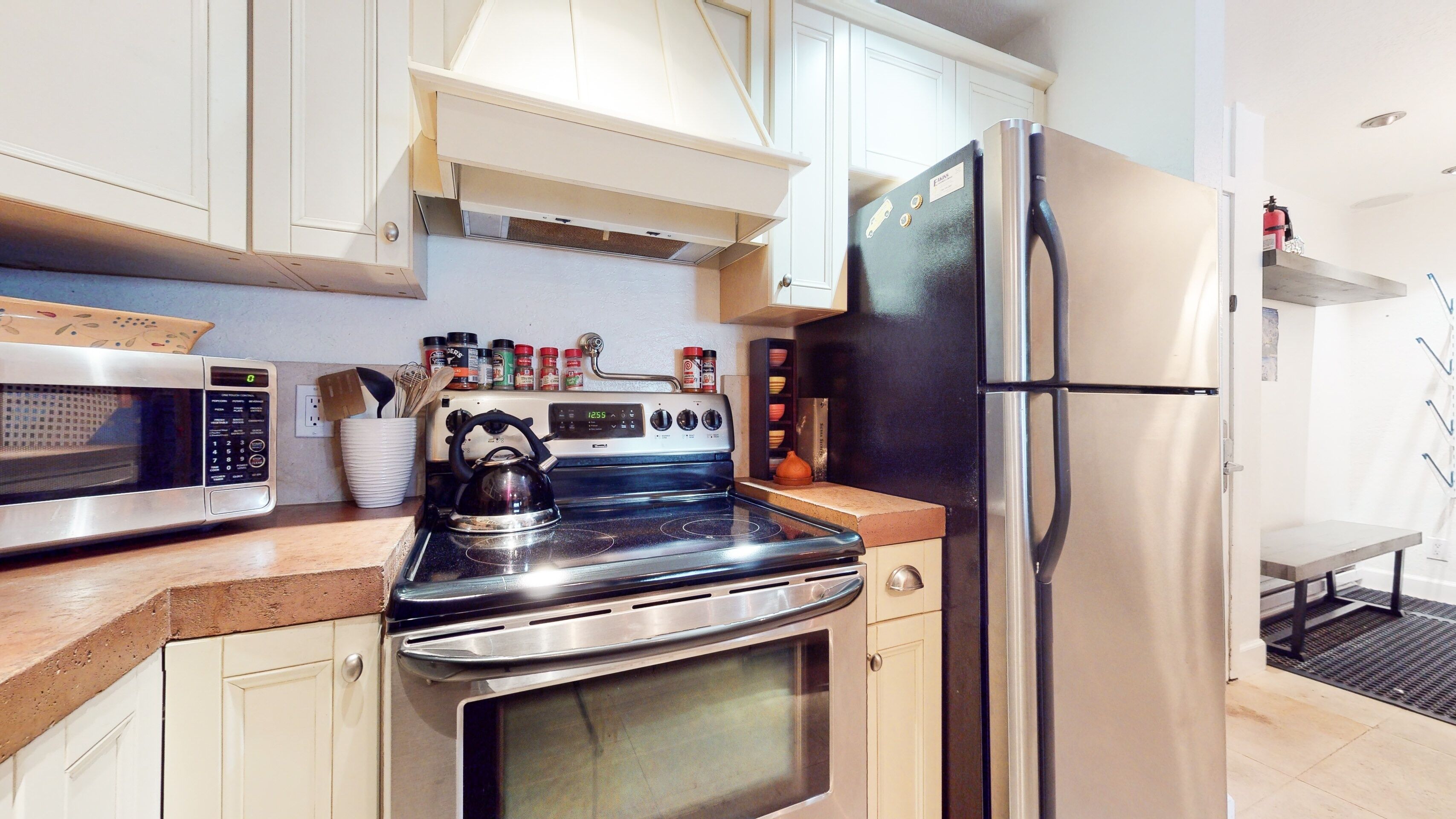 A modern kitchen with stainless steel appliances, including a stove, microwave, and refrigerator.