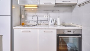 Una cocina moderna con horno empotrado, electrodomésticos de acero inoxidable y una encimera despejada.