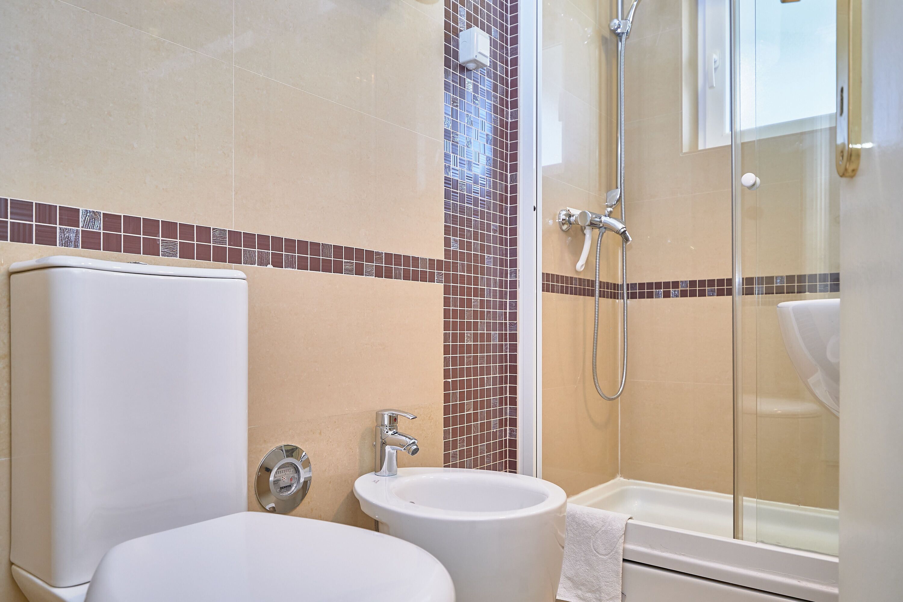 A bathroom with a toilet, sink, and shower.