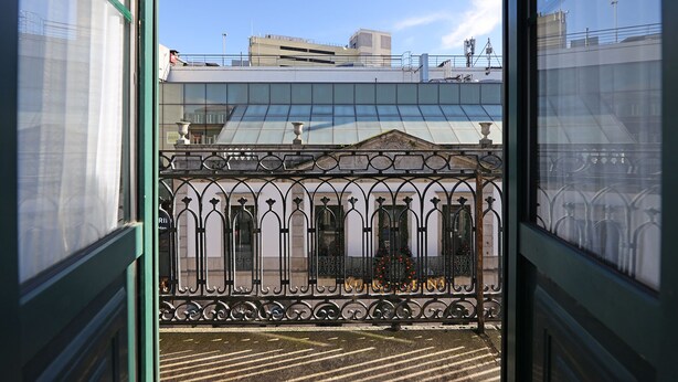 A view through a window of a building with a metal fence and a clear sky. - FLH Porto Downtown GuestHouse (Porto)