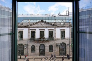 A historic building with a classical facade, arched windows, and a central balcony with a decorative wreath. - FLH Porto Downtown GuestHouse (Porto)