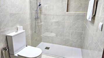 Un baño moderno con inodoro, ducha y toallero.