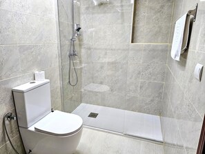 Een douche, handdoeken, zeep, shampoo