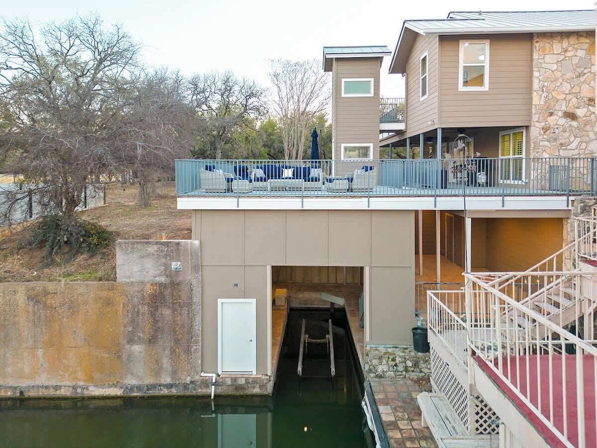 Un edificio con un canal de agua, un paseo techado y un muro de piedra.