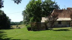 A stone house with a tiled roof, surrounded by a well-maintained lawn and trees. - Le Séchoir, Cottage of 75 m2 for 2 people with swimming pool, large park (MONMARVES)