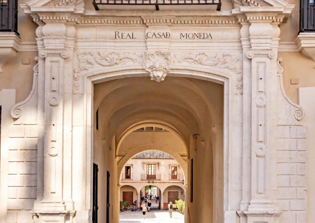 Un arco de entrada con la inscripción 'Real Casa Moneda'.