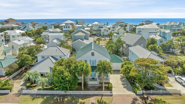 A coastal residential area with houses featuring gabled roofs and front porches, surrounded by palm trees and a white picket fence. - Sleeps 16 / Walk to Beach / 6BR w/ Bunk Room / Perfect for Families & Groups (Destin)