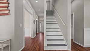 A staircase with white railings and dark steps leading to a second floor. - Sleeps 16 / Walk to Beach / 6BR w/ Bunk Room / Perfect for Families & Groups (Destin)