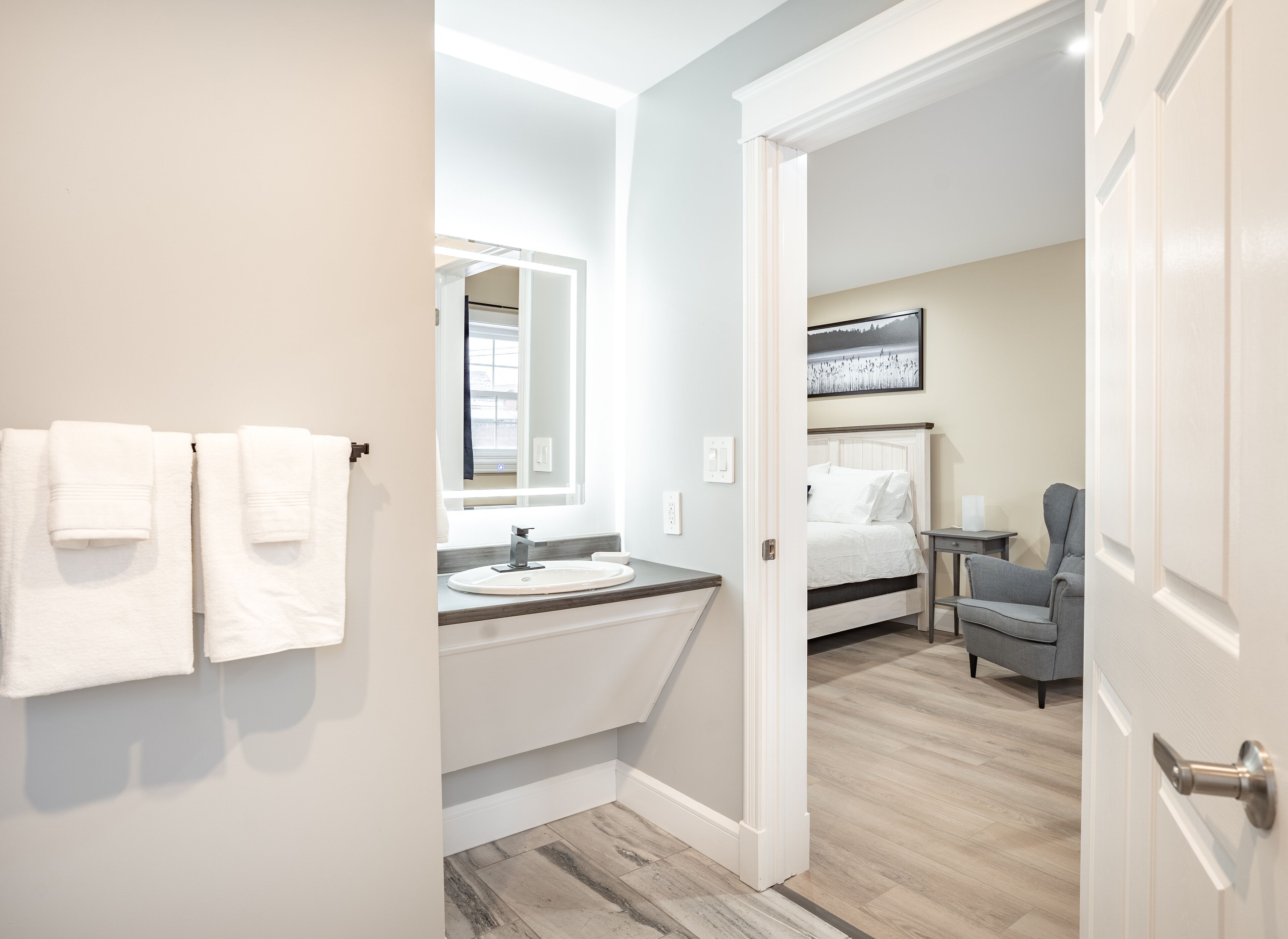 Une salle de bain avec un lavabo, un miroir et des serviettes.