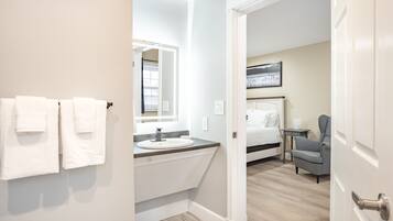 Une salle de bain avec un lavabo, un miroir et des serviettes.