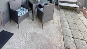 An outdoor patio with a covered seating area, a table, and chairs. - Pink Flamingo-Pet-Friendly + Walk to Beach & Dining, Fenced courtyard (North Myrtle Beach)