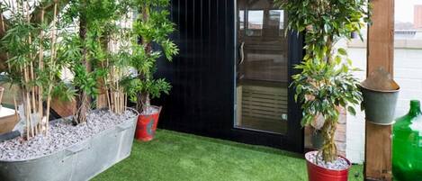 A garden with various potted plants and a small lawn area.