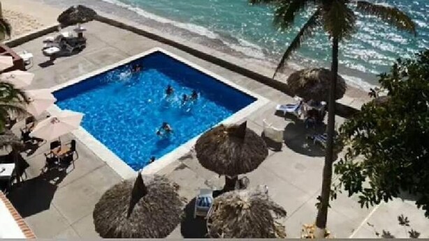 Un espace piscine offrant une vue sur la mer et une île.