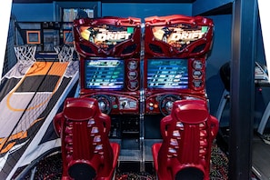Dos máquinas de carreras de videojuegos con un aro de baloncesto y un suelo a cuadros.