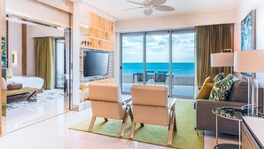Ein modernes Hotelzimmer mit Balkon, einem Flachbildfernseher und einer Sitzecke mit zwei Stühlen.