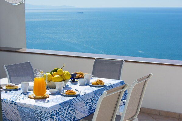 A table with breakfast items and a view of the sea. - Casa Darly (Positano)