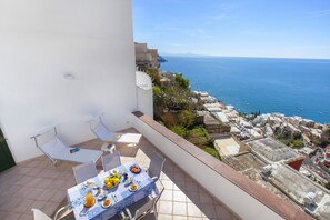 A balcony with a table set for breakfast overlooking the sea. - Casa Darly (Positano)