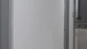 A corridor with a door on the right and a mirror on the left. - Depas Tramonto (Mazatlán)