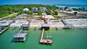 Une propriété située sur la côte, comprenant plusieurs bâtiments, un quai et une plage.