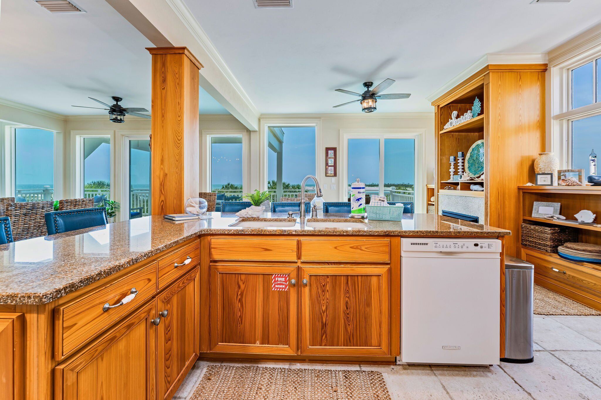 A spacious kitchen with wooden cabinets, granite countertops, and a built-in dishwasher.