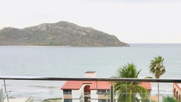 A balcony with a view of the sea and a distant island. - Condos TT (Mazatlán)